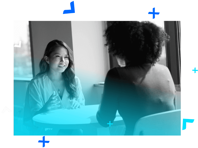 Two women talking at a small white table