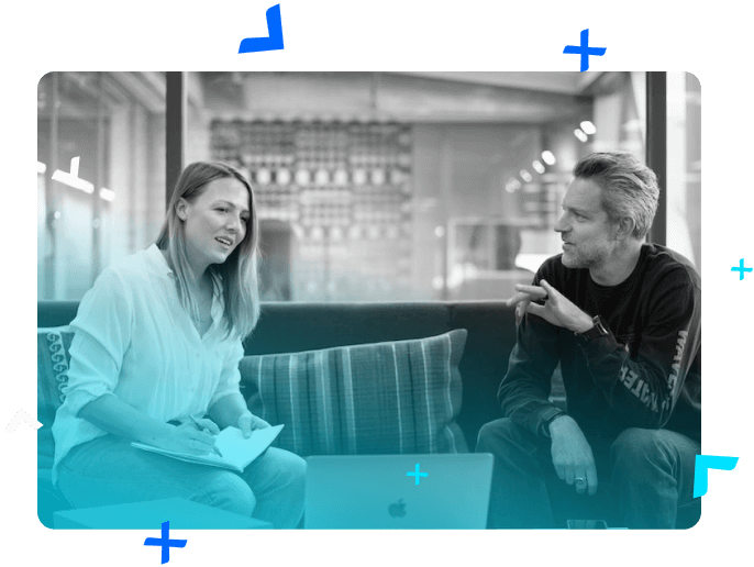 A woman and a man talking seated in a coworking space