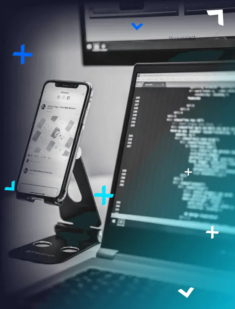 A laptop next to a phone holder with a smartphone.